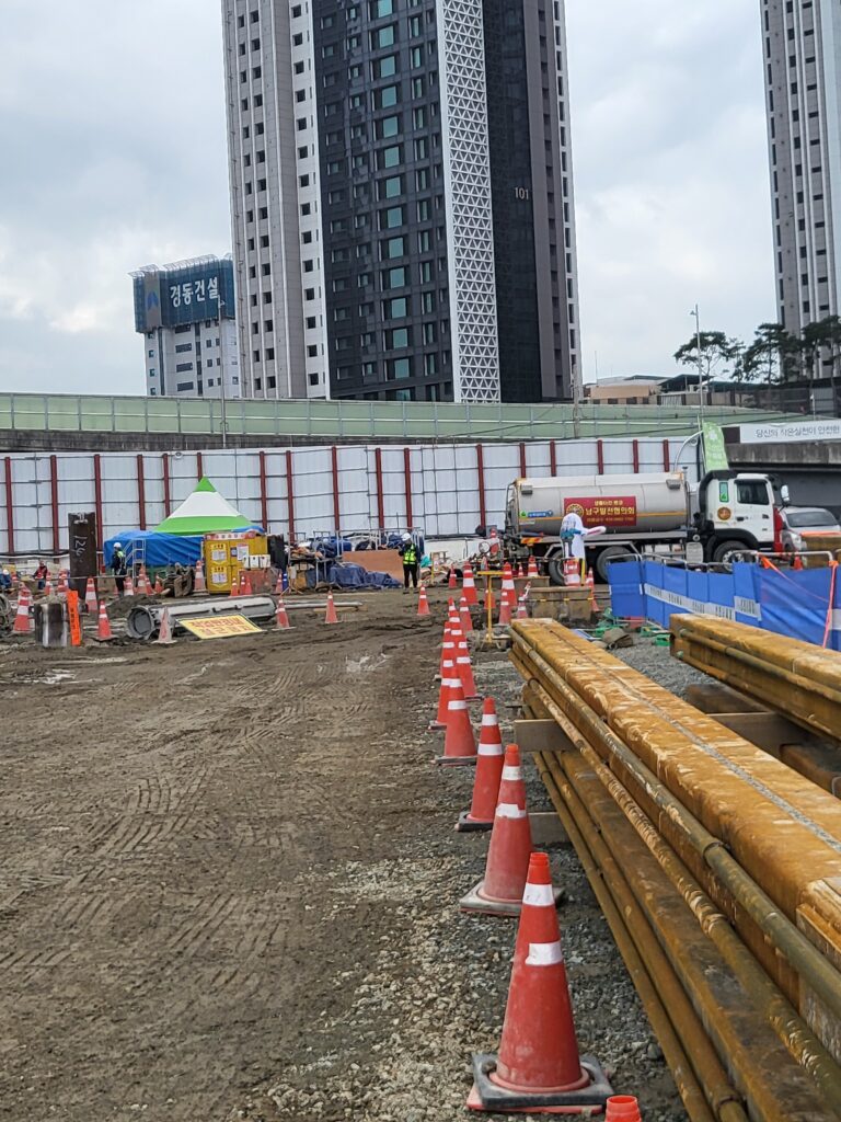 { "title": "h빔 흙막이 기초공사 현장일지 | 안전작업 핵심정리", "wp draft": "🏗️ 오늘의 현장 개요 — h빔 근입(흙막이 벽체 설치) 작업n자, 오늘도 어김없이 현장일지 한 장 남깁니더. 30년 넘게 흙 파고 철근 박아온 소장 입장에서 오늘 작업 하나하나 짚어드릴 테니, 현장 처음 나온 신참 아재들도 단디 읽어보소.n오늘 핵심 작업은 h빔 항타(h pile 타입) — 쉽게 말해 저 시뻘건 h자 모양 철골 기둥을 땅속에 일정 간격으로 박아 넣는 거라. 이게 바로 흙막이 가시설(토류벽)의 뼈대가 되는 기라카이. 옆에 흙이 무너지지 말라고 버텨주는 임시 구조물인데, 임시라고 얕보면 절대 안 됩니더. 이거 부실하면 옆집 땅 꺼지고 인명사고까지 이어지는 무서운 공정이라.nn🔨 세부 작업 내용n① h빔 항타 작업nn 규격: 현장 설계도서 기준 h 300×300 계열 추정 (녹 상태로 보아 야적 기간 있었음)n 장비: 항타기(바이브로 해머 또는 유압 해머) 투입해서 소정 깊이까지 근입(땅속 박기)n 간격: 설계 도면상 토압(흙이 미는 힘) 계산 기준으로 일정 피치(간격) 유지n 녹슨 빔 사용은 구조 강도에 영향 없으나, 표면 상태 육안 검사 후 심한 단면 결손 있으면 즉시 교체해야 합니더nn② 살수차(물차) 운영nn 항타 및 굴착 작업 시 비산먼지(날리는 흙먼지) 발생 억제 목적n 관련 법령: 비산먼지 발생 사업장 신고 및 저감 조치 의무 (대기환경보전법)n 오늘 아침 살수 1회 + 작업 중 수시 살수 — 기라카이, 이거 그냥 먼지 막는 거 아이고 민원 예방이랑 법적 의무라 빠지면 안 됩니더nn③ 부지 정리 및 기초 지반 다짐nn 아침 비로 인한 노면 연약화(땅이 물러진 상태) 확인 후 작업 구역 지반 상태 점검n 중장비 이동 구간 우선 확인, 필요 시 철판(작업용 깔판) 추가 포설nnn🌥️ 오늘 날씨 및 작업 환경n하늘이 잔뜩 찌뿌둥하이 흐렸심더. 땡볕 없으니 체감온도는 낮았는데, 그게 오히려 작업 효율은 좋았지예. 다만 아침에 살짝 내린 비로 지반 함수율(땅속 수분 함유량)이 올라가가 질퍽한 구간 생겼심더. 이런 날일수록 장비 바퀴 미끄럼, 작업자 발목 부상 조심해야 하는 기라.nn⚠️ 오늘의 안전 관리 포인트n현장 소장이 아침 조회 때 직접 강조한 사항nn 미끄럼 재해 예방 — 질퍽한 지반에서 발 헛딛으면 염좌(삔 것) 넘어서 골절까지 간다. 안전화 끈 단디 묶고, 이동 시 두 발 항상 확인하소.n 장비 작업반경 접근 금지 — 항타기, 굴착기 선회(돌아가는 구간) 반경 내에 절대 들어가면 안 됩니더. 오늘도 '작업반경내 접근금지' 표지판이랑 안전 콘(꼬깔콘) 촘촘이 설치했심더.n 신호수(유도자) 배치 — 중장비 이동 시 반드시 신호수 1명 이상 전담 배치, 이건 산업안전보건법 의무사항이라 빠지면 과태료 바로 나온다.n 개인보호구(ppe) 착용 철저 — 안전모, 안전화, 안전조끼 3종 세트는 기본 중의 기본. 이거 안 쓰고 현장 들어오면 소장이 직접 내보낸다.nnn📋 내일 작업 예정nn h빔 추가 근입 구간 작업 연속 진행n 기 설치 구간 수직도(빔이 똑바로 박혔나) 측량 확인n 날씨 우천 예보 시 지반 상태 재확인 후 작업 여부 결정nnn현장 일이 고되도 기초공사 단계에서 제대로 해놔야 나중에 골치 안 씁니더. 오늘 하루 다들 무사히 마무리해줘서 진짜 고맙고, 내일도 다치지 말고 봅시데이!nn[현장 검색 태그] #h빔흙막이 #기초공사현장 #항타작업 #건설현장일지 #토류벽시공", "naver content": "📌 [네이버 발행용]nn제목: h빔 흙막이 항타 기초공사 현장일지 안전핵심nn아따, 오늘도 현장에서 땀 뻘뻘 흘리고 왔심더! 오늘 주 작업은 h빔 항타(h자형 철골 기둥을 땅속에 박아 넣는 것) 및 흙막이 가시설(토류벽·옆 흙 무너짐 막는 임시 구조물) 설치라. 저 시뻘겋게 녹슨 빔들, 보기엔 좀 그래도 구조 강도는 이상 없는 기라카이. 아침에 비가 살짝 왔다가 말아가 땅이 질퍽질퍽했는데, 그게 제일 무섭심더. 발 헛딛으면 골절까지 이어지는 기라. 그래서 아침 조회 때 목에 핏대 세워가 강조했지예 — 발 밑 단디 보고, 장비 작업반경(선회 구간) 절대 들어가지 말라고예. 안전콘(꼬깔콘)이랑 접근금지 표지판도 촘촘이 박아놨고, 신호수(장비 유도 전담 작업자)도 빠짐없이 배치했심더. 살수차(물차)로 비산먼지(날리는 흙먼지) 억제도 하고, 기초공사 하나하나 단디 챙기는 기 나중에 튼튼한 건물 만드는 지름길이라. 오늘도 우리 식구들 다 무사히 퇴근했으니 그게 제일 큰 성공 아이겠능교!nn👉 전체 내용: https://gongguri.comnn#h빔흙막이 #기초공사현장 #항타작업 #건설현장일지 #토류벽시공", "excerpt": "아침 비로 질퍽해진 지반 위에서 h빔 항타 및 흙막이 가시설 설치 작업을 강행한 빡센 하루였심더. 장비 작업반경 접근 통제와 미끄럼 재해 예방을 최우선으로 챙기며 전 공정을 무사히 마무리했습니다." }