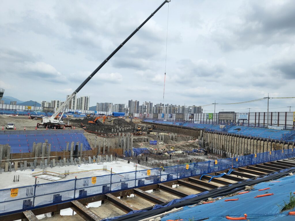 { "title": "기초 터파기 공정별 핵심 품질 관리 포인트", "wp draft": "흐린 하늘 아래 거대한 구덩이가 뻥 뚫려 있고, 굴삭기 두 대가 흙을 퍼내는 소리가 쩌렁쩌렁 울리는 아침이었심더. 크레인은 자재 나를 준비하고, 현장 바닥엔 기초 철근 배근 작업도 동시에 돌아가고 있는 상황이라, 정신 바짝 안 차리면 사고 나기 딱 좋은 현장이었기라카이.nn오늘 현장 상황 총정리n오늘 현장은 한마디로 「터파기+기초배근+크레인 양중」 세 공정이 동시에 돌아가는 복합 공정 현장이었심더. 하늘도 꾸리꾸리한기 금방 비 올 것 같은 날씨에, 땅은 전날 습기 먹어서 질퍽거리고. 이런 날이 제일 위험한 기라.n내가 30년 현장 하면서 가장 아찔했던 순간이 딱 이런 날이었심더. 흐리고 땅 질퍽한 날에 구덩이 가장자리에서 측량하던 측량사 한 명이 발 미끄러져서 아래로 쭉 미끄러지는 거 내 눈으로 봤거든예. 다행히 안전고리 걸려 있어서 살았지만, 그날 이후로 터파기 현장에서 가장자리 접근 시 안전고리는 절대 타협 없는 규칙이 됐심더.nn터파기 공사 핵심 안전 수칙nn굴착면 기울기(사면 구배) 확인 — 흙 종류에 따라 구배 기준이 다른기라. 연약지반은 1:1.5 이상 확보해야 붕괴 안 됩니더.n구덩이 가장자리 1.5m 이내 접근 시 안전고리 필수 — 질퍽한 날은 더 말할 것도 없고, 맑은 날도 무조건 걸어야 하는 기다.n굴삭기 작업 반경 내 인원 통제 — 크레인이랑 굴삭기 동시 작업 시 신호수 반드시 배치하이소.n지하수 용출 여부 수시 확인 — 흐린 날엔 지하수 수위 올라오는 경우 있심더. 배수 펌프 미리 준비해두는 게 맞심더.n안전모 턱끈 체결 상태 확인 — 특히 구덩이 하부 작업자들, 위에서 돌 한 개만 떨어져도 중상이니께 절대 놓치지 마라.nnn기초 철근 배근 작업 시 주의사항n터파기 하부에서 기초 철근 배근 작업이 동시에 진행될 때는, 상부 굴삭기 작업과 충돌이 생기지 않도록 작업 시간대를 반드시 분리하는 게 원칙이심더. 현장 여건상 어쩔 수 없이 동시에 돌릴 때는 신호수 2명 배치, 무전기 상시 통화 상태 유지는 기본 중의 기본이라카이.n배근 작업 시 스페이서(간격재) 설치도 꼼꼼히 봐야 됩니더. 피복 두께가 설계 기준에 안 맞으면 나중에 콘크리트 타설하고 나서 철근 부식으로 이어지는기라. 기초는 건물 몸뚱이 받치는 뿌리인데, 뿌리가 썩으면 윗 건물이 버티겠심니까.nn크레인 양중 작업 안전 관리nn크레인 작업 반경 내 통제선(작업반경+5m) 설정 후 인원 진입 차단n인양 하중 초과 여부 일일 확인 — 과부하 방지장치 작동 여부도 점검하이소n슬링벨트, 샤클 등 인양 보조구 마모·손상 확인은 작업 전 매일 실시n흐린 날 바람 세기 확인 필수 — 순간 돌풍 시 인양 작업 즉시 중단이 원칙이라카이nnn👉 현장 소장 필수 레이저 거리측정기 → 쿠팡에서 확인하기n이 포스팅은 쿠팡 파트너스 활동의 일환으로, 이에 따른 일정액의 수수료를 제공받습니다.nn흐린 날 지반 관리 포인트n오늘처럼 흐리고 습한 날씨에는 터파기 현장 지반 상태가 예민하게 변하심더. 내가 특히 신경 쓰는 건 굴착면 하단부 히빙(heaving) — 쉽게 말하면 굴착 바닥이 부풀어 오르는 현상이라카이. 연약지반에서 굴착 깊이가 깊어질수록 이 현상이 생기는데, 바닥이 꿈틀거리기 시작하면 굴삭기 즉시 빼고 안전 검토 들어가야 됩니더.n또 굴착 사면에 균열이 생기기 시작하면 그것도 붕괴 전조 증상이니께, 현장 반장들은 순찰 돌 때 사면 상태 눈으로 꼭 체크하라고!nn오늘 현장 마무리 총평n복합 공정 현장에서 사고 안 나고 하루 마무리한 거, 그게 제일 큰 성과심더. 내일은 지반 상태 다시 한 번 점검하고, 굴삭기 작업 구역이랑 배근 작업 구역 동선 재정비해서 충돌 없이 돌아가도록 아침 조회 때 팍 잡아야겠심더. 다들 오늘 하루 고생 많았고, 뜨신 밥 한 끼 든든하게 챙겨 묵어라!nn📱 현장에서 바로 쓰는 앱 → 공사판 김반장 무료 설치n더 많은 현장 노하우는 공구리닷컴에서 확인하이소!nn[현장 검색 태그] #터파기안전 #기초공사 #철근배근 #크레인양중 #건설현장안전", "naver content": "📌 [네이버 발행용]nn제목: 기초 터파기 공정별 핵심 품질 관리 포인트nn아, 김반장이다. 오늘 하루 정리하자!nn흐린 하늘 아래 굴삭기 두 대가 땅 퍼내는 소리 쩌렁쩌렁 울리는 아침이었심더. 터파기에 기초 배근에 크레인 양중까지, 세 공정이 동시에 돌아가는 복합 현장이라 정신 바짝 차려야 했기라카이.nn오늘 같은 흐리고 습한 날씨, 땅이 질퍽거려서 구덩이 가장자리 미끄러지면 바로 황천길이다. 안전고리 필수, 안전모 턱끈 꽉, 굴삭기 작업 반경 안에 얼씬도 하지 마라!nn내가 30년 현장에서 가장 아찔했던 순간도 딱 이런 날 터파기 가장자리에서 발 미끄러진 사람 봤을 때였심더. 안전고리 덕에 살았지, 없었으면 끝났기라.nn내일도 안전모 단디 쓰고, 밥 잘 챙겨 묵고 현장 보자고!nn👉 전체 내용: https://gongguri.comnn#터파기안전 #기초공사 #철근배근 #크레인양중 #건설현장안전", "excerpt": "흐린 하늘 아래 터파기·기초배근·크레인 양중 세 공정이 동시에 진행된 복합 공정 현장 일지입니다. 지반 미끄러움과 구덩이 추락 위험이 공존하는 현장의 핵심 안전 관리 포인트를 정리했심더.", "odap location": "흐린 날 지반 관리 포인트", "odap html": "n🚨 스마트 김반장의 ai 조련 일지 [№] (팩트 폭행 코너)nn[대장님의 날카로운 지적]:n사진 보니께네, ai 녀석이 『크레인은 오늘 자재 좀 나를 끼고』 카면서 크레인이랑 굴삭기를 그냥 당연하다는 듯이 동시 작업으로 묶어버렸기라카이. 사진 속에 굴삭기 작업 반경이랑 크레인 선회 반경이 겹쳐 보이는 게 눈에 딱 들어오는데, 이걸 그냥 『정신없을끼다』 한 마디로 넘기는 거, ai 짬밥 수준이 딱 보이는 기 아이가!n[김반장의 한마디]:n크레인이랑 굴삭기가 작업 반경 겹치는 상황에서는 동시 작업 자체가 원천 금지입니더. 이걸 『동시에 돌리면 신호수 넣으면 된다』고 대충 퉁치는 현장도 있는데, 「건설기계 작업계획서」 기준상 반경 충돌 구간은 한 개 기계 작업 중단 후 순차 작업이 원칙이라카이. 크레인 인양 중에 굴삭기 버킷이 선회하다 와이어 건드리면 그날로 대형 사고 나는 기다. ai한테 한 수 가르쳐줬으니께, 다음부턴 작업계획서 먼저 읽고 말하라고 전해라!nnn반장님들, 이거 보시니까네 ai 녀석 짬밥 참 처참하지예? 댓글로 훈수나 의견 한마디씩 팍팍 보태주이소!nnn📌 다음 편 예고: 기초 버림 콘크리트 타설 후 먹매김 작업, 어디서 오차 생기는지 파헤쳐봅니더!nn" }